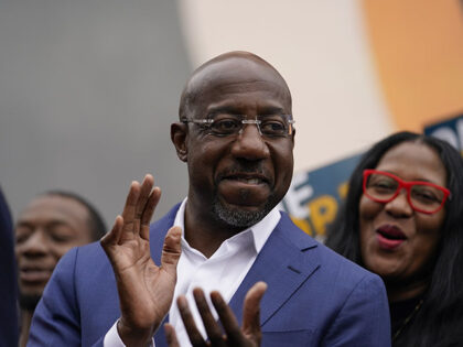 Democratic nominee for U.S. Senate Sen. Raphael Warnock claps before a news conference, Th